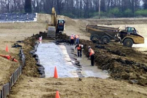 Workers Expose the Cell 6 Liner to Prepare the Surface for Attachment to the Cell 7 Liner.
A balanced approach to waste disposition has been developed at Fernald, one in which the majority of the site's contaminated material will be placed in an On-Site Disposal Facility (OSDF) for its final disposition, where as, a smaller volume of more highly contaminated waste will be sent off site. The OSDF is being constructed on the east side of the Fernald Site and will ultimately hold approximately 2.5 million coubic yards of impacted material. The facility is being constructed in phases. Phase V consists of waste placement in Cells 3, 4, 5 and 6, construction of the Cell 7 and 8 liners, the placement of the final cover on all remaining cells and screening of clay liner and cover material in the Borrow Area. 
Keywords: Fernald Closure Project Fernald Green Salt Plant, Feed Materials Production Center, Fernald, Ohio (FEMP)