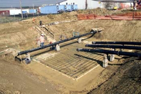 An Iron Worker Installs Rebar at Valve House 7.
A balanced approach to waste disposition has been developed at Fernald, one in which the majority of the site's contaminated material will be placed in an On-Site Disposal Facility (OSDF) for its final disposition, where as, a smaller volume of more highly contaminated waste will be sent off site. The OSDF is being constructed on the east side of the Fernald Site and will ulimately hold approximately 2.5 million cubic yards of impacted material. The facility is being constructed in phases. Phase V consists of waste placement in Cells 3, 4, 5 and 6, construction of the Cell 7 and 8 liners, the placement of the final cover on all remaining cells and screening of clay liner and cover material in the Borrow Area. 
Keywords: Fernald Closure Project Fernald Green Salt Plant, Feed Materials Production Center, Fernald, Ohio (FEMP)