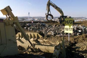 Operating Engineers use Grapplers and Bulldozers to Place and Compact Demolition Debris in Cell 4 of the On-Site Disposal Facility (OSDF).
A balanced approach to waste disposition has been developed at Fernald, one in which the majority of the site's contaminated material will be placed in an On-Site Disposal Facility (OSDF) for its final disposition, where as, a smaller volume of more highly contaminated waste will be sent off site. The OSDF is being constructed on the east side of the Fernald Site and will ultimately hold approximately 2.5 million cubic yards of impacted material. The facility is being constructed in phases. Phase V consists of waste placement in Cells 3, 4, 5, and 6, construction of the Cell 7 and 8 liners, the placement of the final cover on all remaining cells and screening of clay liner and cover material in the Borrow Area. 
Keywords: Fernald Closure Project Fernald Green Salt Plant, Feed Materials Production Center, Fernald, Ohio (FEMP)