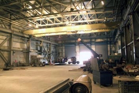 Workers Finish Installing a Bridge Crane in the Silos 1 and 2 Treatment Facility that will be used to Load the Waste Containers for Transportation Off Site.
8,900 cubic yards of high activity low-level waste material will be removed from Silos 1 and 2, processed and shipped off site for disposal. This material was generated from 1951 to 1960 as a waste by-product from the processing of high-grade uranium ores. The Silos 1 and 2 material, also known as K-65 material, contains radium and throium radioclides. Waste Retrieval Project will consist of six major systems; Silos Waste Retrieval System; Decant Sump Waste Retrieval System; Transfer Tank Area; Transfer Tank Waste Retrieval System; Radon Control System; and the Full Scale Mock-Up System. Once the waste is removed from the silos it will then be stabilized with a formulation of flyash and Portland cement before being containerized for shipment. 
Keywords: Fernald Closure Project Fernald Green Salt Plant, Feed Materials Production Center, Fernald, Ohio (FEMP)