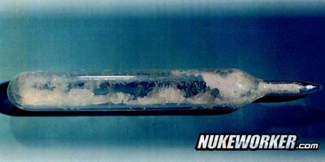 Uranium Hexafluoride (UF6)
Uranium hexafluoride is a chemical compound consisting of one atom of uranium combined with six atoms of fluorine. It is the chemical form of uranium that is used during the uranium enrichment process. Within a reasonable range of temperature and pressure, it can be a solid, liquid, or gas. Solid UF6 is a white, dense, crystalline material that resembles rock salt.

 
UF6 crystals in a glass vial.
Uranium hexafluoride does not react with oxygen, nitrogen, carbon dioxide, or dry air, but it does react with water or water vapor. For this reason, UF6 is always handled in leak tight containers and processing equipment. When UF6 comes into contact with water, such as water vapor in the air, the UF6 and water react, forming corrosive hydrogen fluoride (HF) and a uranium-fluoride compound called uranyl fluoride (UO2F2).
Keywords: Oak Ridge K-25 (ETTP)