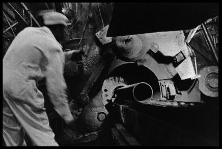 The Back End of the Ashtabula Press
A worker waits for an extrusion of uranium metal to exit form the press. 

Reactive Metals, Incorporated, Ashtabula, Ohio. June 19,1984.
Keywords: Reactive Metals, Incorporated, Ashtabula, Ohio