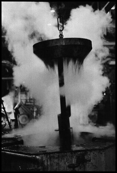 Ashtabula Quench
The newly extruded uranium metal, hot out of the press, is cooled in air for 6 minutes, then dunked in a quench tank. Quenching sends clouds of steam mixed with uranium oxide into the factory air. Reactive Metals, Incorporated, Ashtabula, Ohio. June 19, 1984. 
Keywords: Reactive Metals, Incorporated, Ashtabula, Ohio