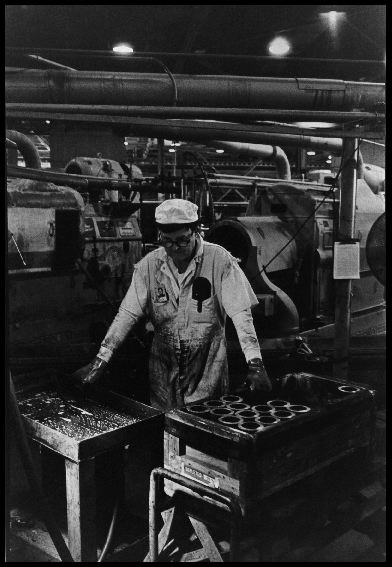 Back to Fernald
Ashtabula returns uranium metal, in the form of long tubes, to Fernald. A worker stands by while a blanking machine cuts the metal into 14-inch segments, each weighing 28 pounds. These are Fernals's top product: Mark 31 Target Element Cores. They are called target element cores because at Department of Energy reactors elsewhere the will be bombarded with neutrons and transformed into weapons-grade plutonium. 

Feed materials Production Center, Fernald, Ohio. December 17, 1985. 
Keywords: Fernald Green Salt Plant, Feed Materials Production Center, Fernald, Ohio (FEMP)