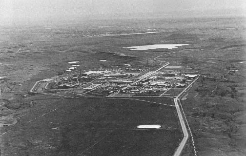 Rocky Flats
Rocky Flats handles more plutonium than any other facility in the Western world. It manufactures the uranium and plutonium "pits" used in the fission triggers of thermonuclear bombs. The pit is the ball of uranium or plutonium inside the bomb's sphere of chemical high explosives. Rocky Flats also fabricates beryllium neutron reflectors to increase the yield of exploding fission triggers. The plant employs 6,000 people. It is 126 miles upwind from Denver and half a mile form the Great Western Reservoir, visible above the plant. This reservoir serves the nearby town of Broomfield (pop.26, 000). Golden, Colorado. July 17, 1983. 
Keywords: Rocky Flats Plant Nuclear Bomb Facility Environmental Technology Site RFETS