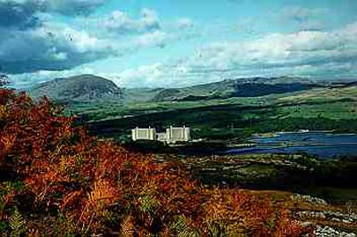 Trawsfynydd
Trawsfynydd Power Station lies within the boundaries of a National Park of considerable beauty and is located on the northern bank of Llyn Trawsfynydd. 

Following the decomissioning of the plant, the existing building structure is to be reduced in height and encased in a new 'Safestore' envelope. The objective is to reduce and in some cases eliminate the buildings impact within the National Park.

The Safestore structure is to provide an aesthetically acceptable, cost effective means of long term, secure storage for specific radioactive materials and structures. As well as minimising the visual impact of the site the structure is based on the following criteria:

The design life shall be 135 years. During the majority of this period it is proposed that the site will be unmanned. The structures shall be intruder resistant with a 9m wall also giving an improved visual balance between the lower and upper levels of the external elevations. 
 
The landscape within the site boundary will reflect the character of the natural surrounding landscape so the there are no visible boundaries and the landscape flows naturally through the site.
Keywords: Trawsfynydd Safestore UK