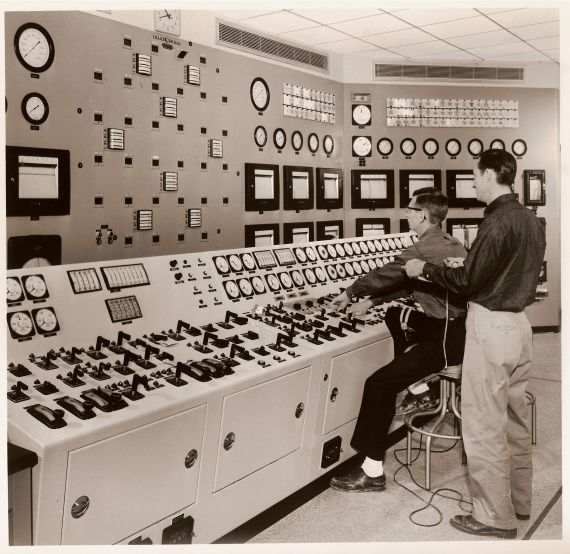 Big Rock Control Room
Publicity photo from Consumers Power; accompanying caption reads "In the 'brains' of a nuclear plant - the control room of Consumers Power Company's Big Rock Point Nuclear Plant, near Charlevoix.  Operators are timing the insertion and withdrawal of the 32 control rods in the reactor, a check made each time before each plant 'start-up.'  Directly in front of the men, a panel shows the location of the control rods inside the core of the reactor."
Keywords: big rock point control room