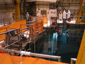 Caorso workers in white suits beside pool