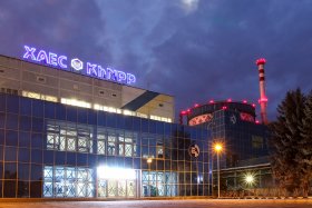 Khmelnitskiy plant building with lit sign at dusk